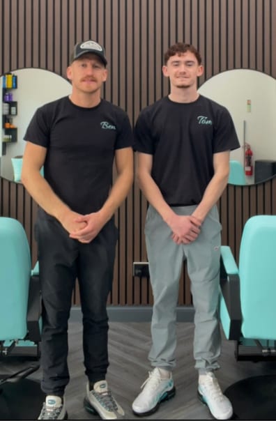 Ben and Tom, the barbers at Image Barberz, standing between the shop's turquoise chairs